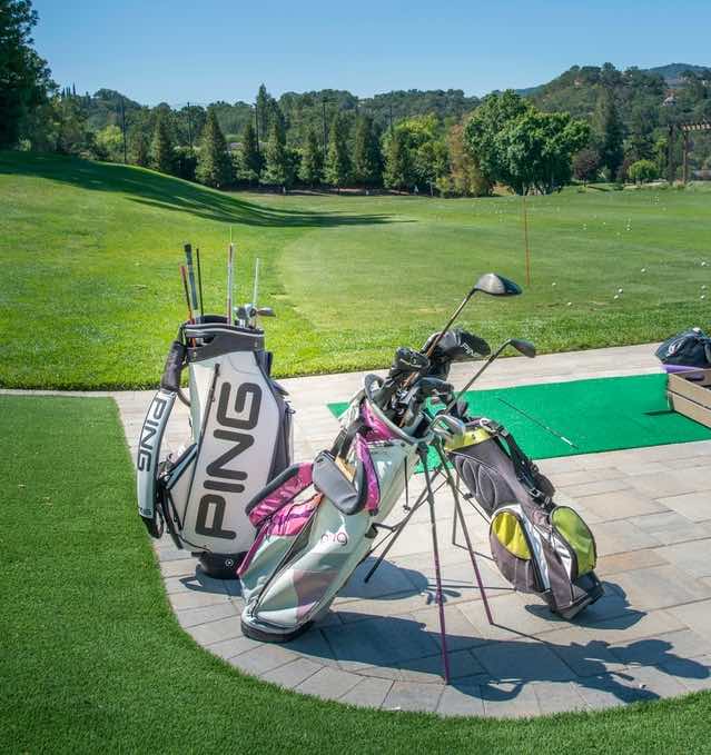 Golf bags positioned close to driving range somewhere in California