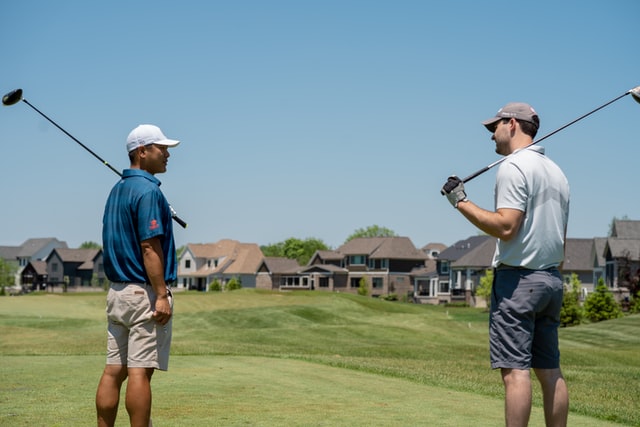 Golf instructor speaking slice with student.